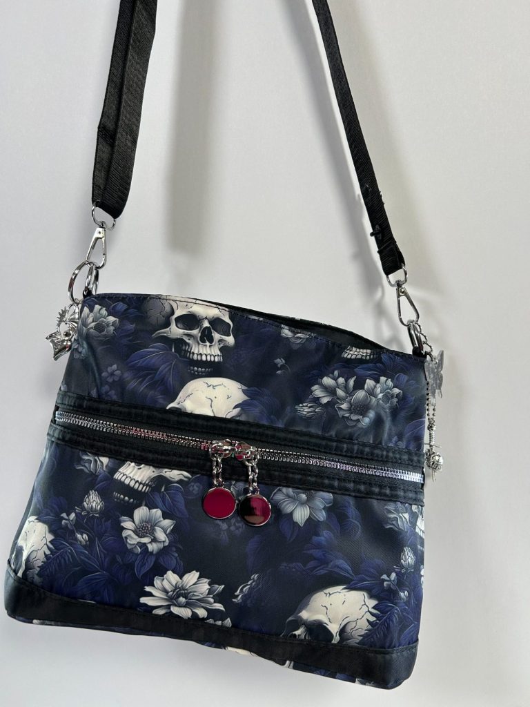 Decorated Goth Purse A black Goth style black purse with skulls and other objects on it.
